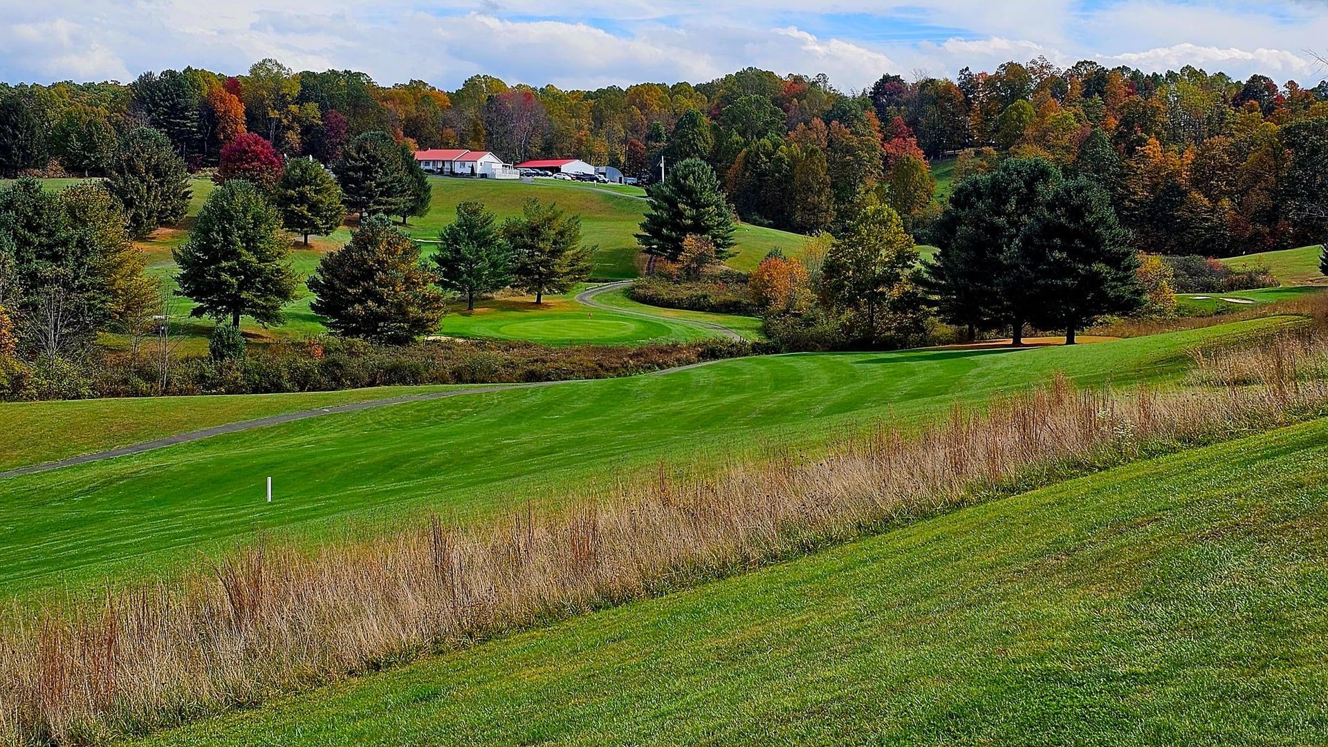 The rolling hills of a golf course with the clubhouse visible in the distance