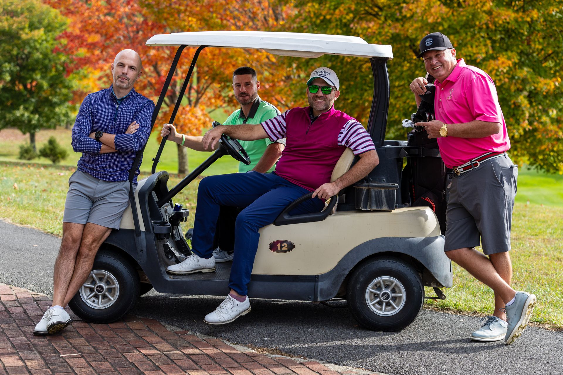 A group of golfers around a golf cart